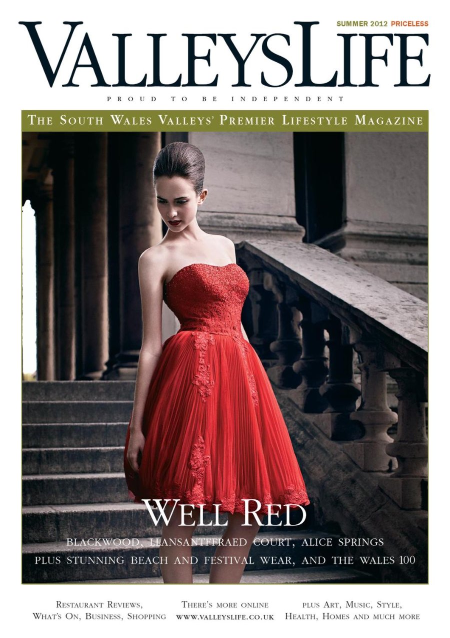 Valleys Life Summer 2012 cover. A model with dark hair pinned up wears a strapless red dress with a lace bodice and full pleated skirt, standing on the stone steps of a grand colonnaded building. Headline: Well Red.