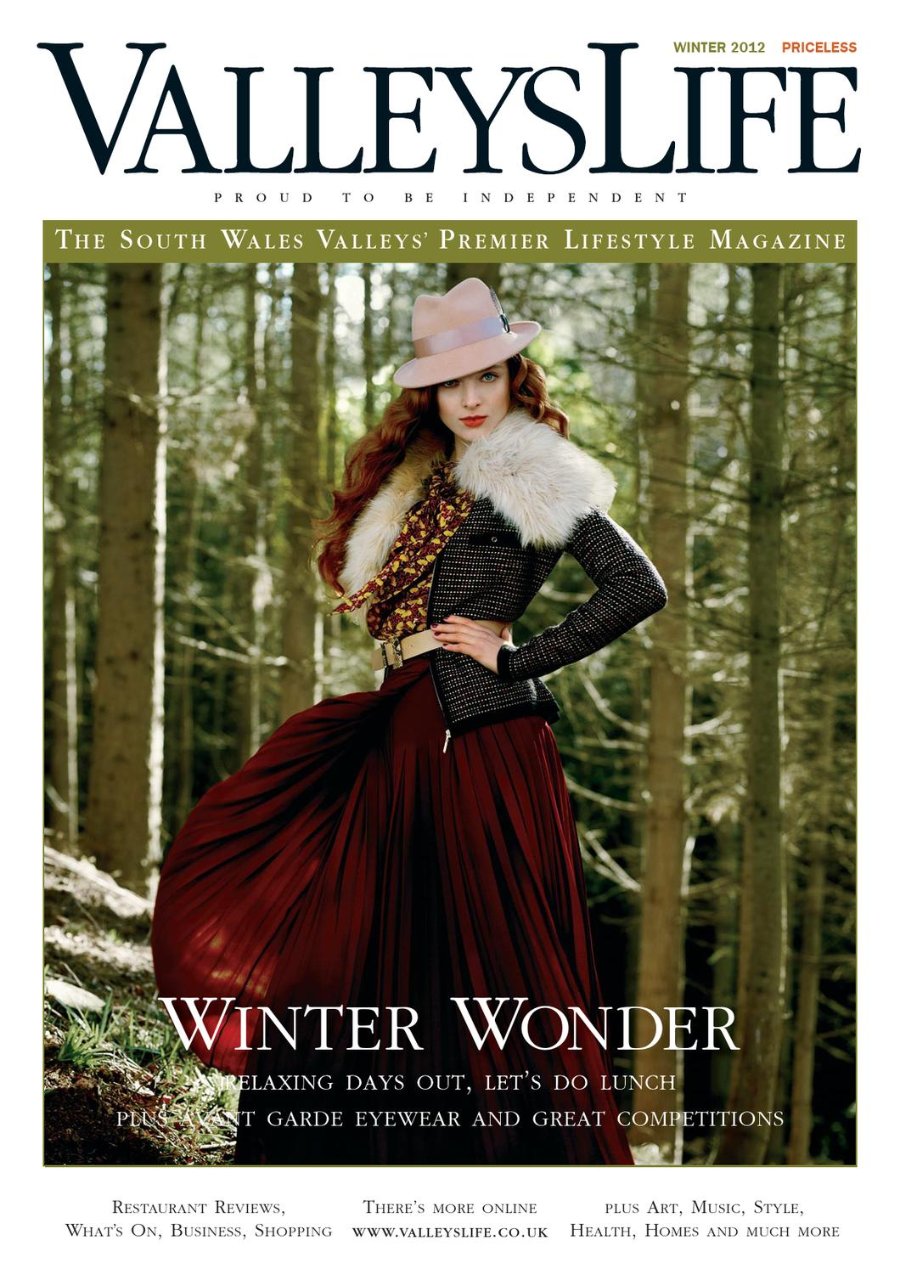 Valleys Life Winter 2012 cover. A model with long auburn hair wears a pale pink wide-brimmed hat, a sheepskin collar over a black quilted jacket, a patterned blouse and a full burgundy skirt, standing with a hand on her hip in a pine forest. Headline: Winter Wonder.