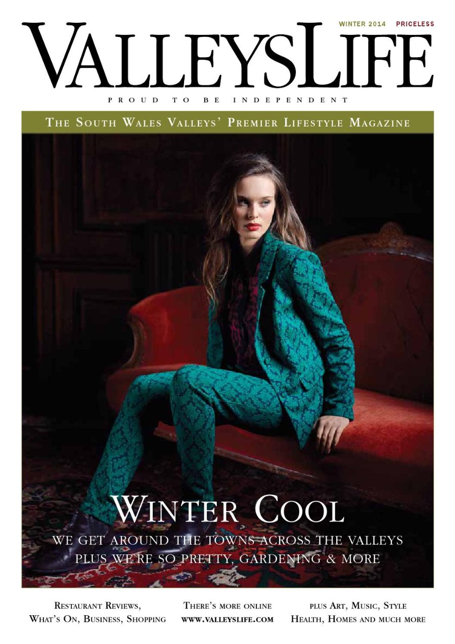 Valleys Life Winter 2014 cover. A model with long fair hair and red lipstick, in a teal and black patterned trouser suit with a dark printed blouse, sits on a red velvet chaise longue on a patterned rug in a dark wood-panelled room. Headline: Winter Cool.